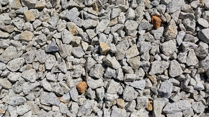 Close-up of grey crushed stones used for construction, building foundation, and road material.