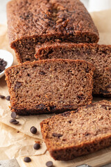 Chocolate zucchini bread cake sliced. Moist chocolate cake with grated zucchini, cocoa powder and chocolate chips on wooden board close up