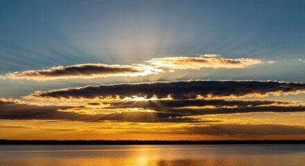 Sunset over water with dramatic crepuscular rays through clouds