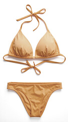 Elegant gold bikini lying on white background is ready for summer vacation