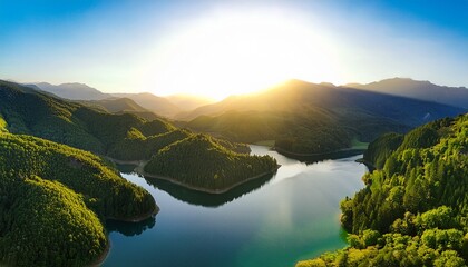 a beautiful landscape of green mountains and a lake in the morning with a sunrise sky this nature scene showcases a watershed forest highlighting water and forest sustainability the aerial view re