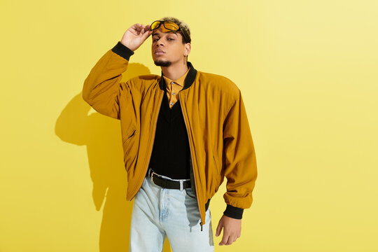 Young Black man shows off trendy style in a colorful modern studio