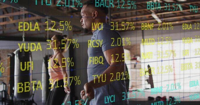 African American man skipping rope in sportswear in warehouse gym, with punching bag