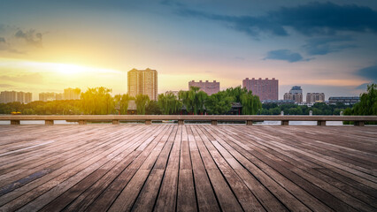 Sunset view of wooden platform with city buildings in the background