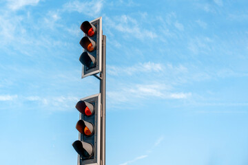 Traffic signal showing red light at an intersection near modern buildings on a cloudy day