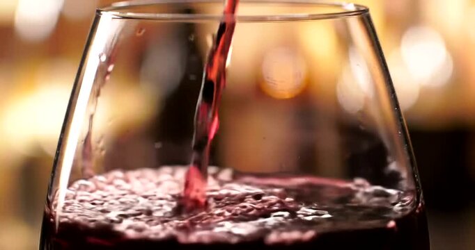 Pouring Red Wine into Elegant Glass.