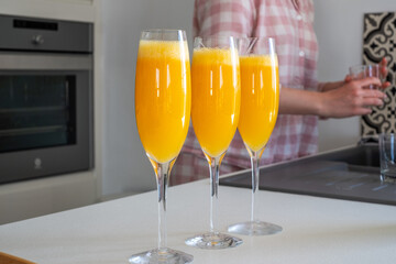 Fresh and delicious mimosas served in elegant flutes, showcasing vibrant orange hues, perfect for a festive cocktail party atmosphere with cheerful ambiance and refreshing flavors
