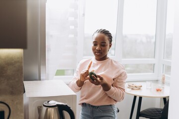 Woman checking avocado ripeness in kitchen
