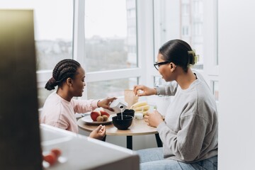 Two black women having breakfast together at home