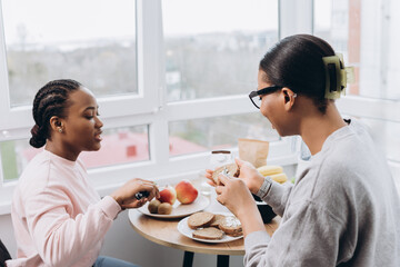 Two black women sharing breakfast and conversation at home