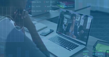 Conducting virtual meeting with colleague on laptop screen in office, smartphone and stock charts