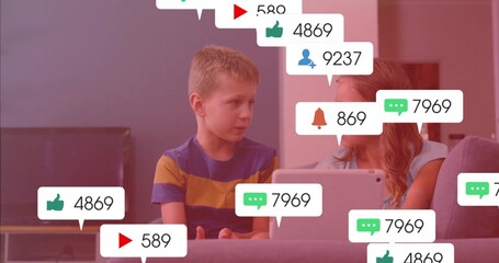 Watching siblings exploring social alerts on tablet in living room with gray couch, flat-screen TV