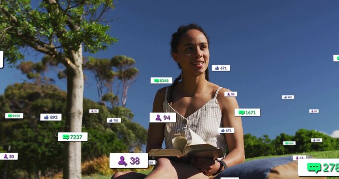 Reading woman wearing fitness watch, striped sundress in park, open book, cushion, digital overlays