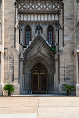 Obraz premium Gothic style church entrance with detailed stonework and two potted plants
