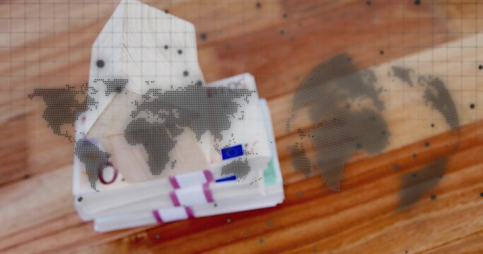 Fototapeta Displaying stacks of euro banknotes with colored straps on wood tabletop, showing world map overlay