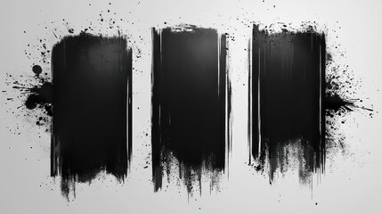 Three black ink brush strokes with splatters on white background.