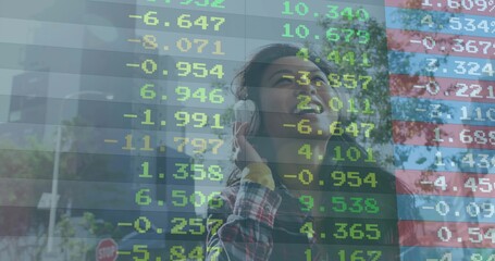 Listening Asian woman holding headphones on city street corner displaying stock ticker overlay