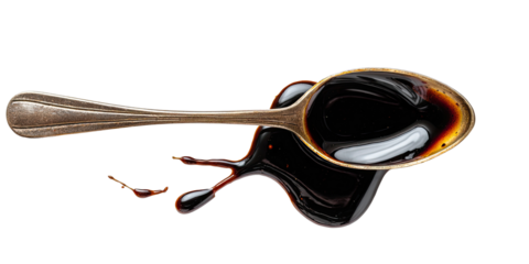 Dark liquid spills from a vintage spoon