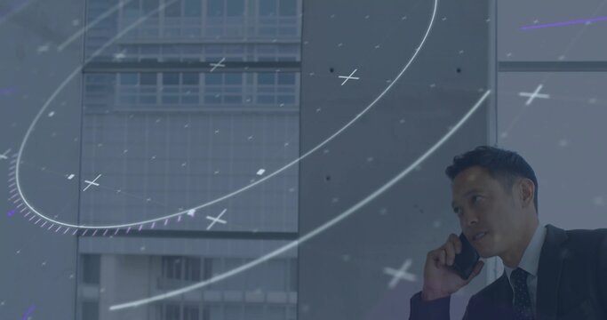 Talking man in business suit using smartphone by office windows with digital overlay, copy space