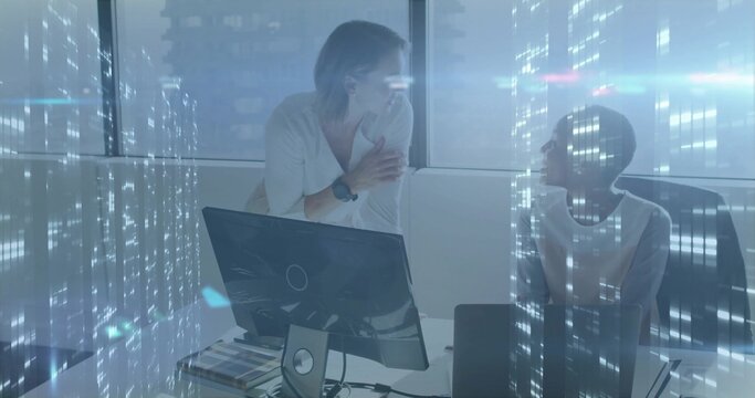 Discussing design two professional women leaning on desk using monitor at office, with swatch book