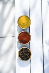 Turmeric Paprika Peppercorns Overhead View in Wooden Bowls on Rustic Wood