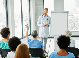 Portrait of a young doctor teaching on a seminar in a board room or during an educational class at...