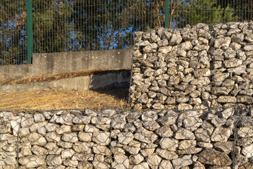 Gabion wall protecting a slope with metal mesh and rocks