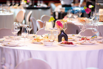 Banquet table served with glasses, food and elegant decoration for wedding or corporate event