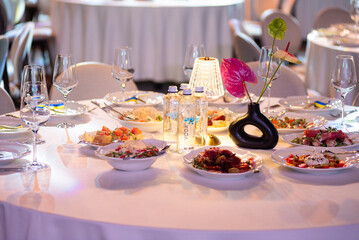 Banquet table served with glasses, food and elegant decoration for wedding or corporate event