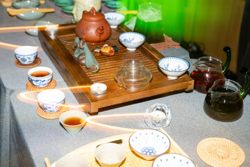 Traditional tea ceremony with clay teapot, cups and herbal tea on wooden table, authentic Asian...