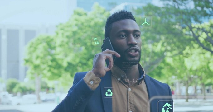 Speaking man wearing navy blazer standing in urban plaza, with smartphone and eco icons floating - Powered by Adobe
