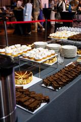 Catering banquet table with assorted snacks, desserts, pastries and appetizers, luxury food service arrangement for corporate event, wedding or festive celebration