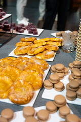 Catering banquet table with assorted snacks, desserts, pastries and appetizers, luxury food service arrangement for corporate event, wedding or festive celebration