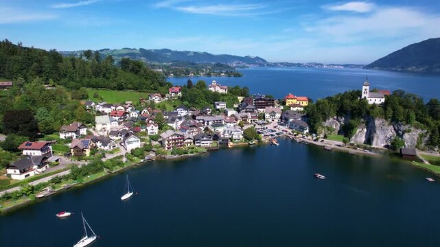 Austria Traunsee aerial view of Traunkirchen village on peninsula with church Alps mountains background drone 4k travel destination scenic Salzkammergut