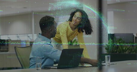 Discussing coworkers wearing colorful attire at office desk, with laptop, water glasses, overlay