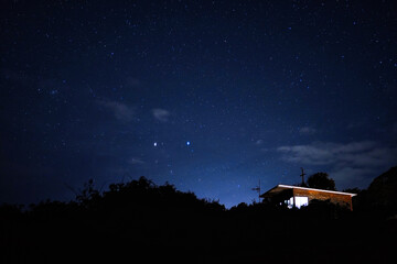 Night sky filled with stars above a glowing bungalow, creating a serene and peaceful atmosphere, outdoors, Azores, Portugal