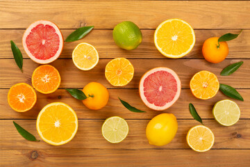 Different citrus fruits on wooden background, top view