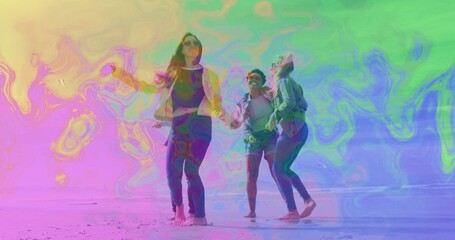 Running friends holding hands on sunny sandy shoreline, wearing jeans, light jackets and sunglasses