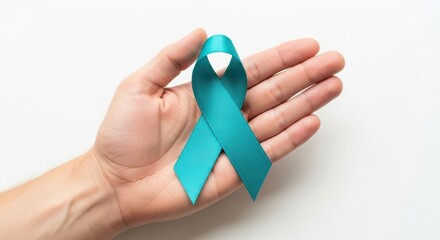 Hand holding a teal awareness ribbon for ovarian cancer, cervical cancer, and other gynecological cancers, isolated on white background