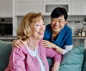 Doctor or nurse caregiver with senior woman talking and having fun at home or nursing home