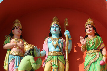  Sita, Rama, Hanuman and Lakshman - Detailed Statues of Hindu Deities on a Temple Wall with Vibrant Red Background. Sacred Scene from Ramayana Epic.