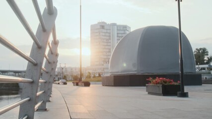 Static shot of young Caucasian man in grey t-shirt and red shorts running on promenade - Powered by Adobe