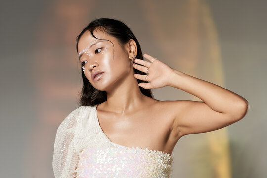 Fototapeta Captivating creative makeup with pearls on a young Asian woman in studio setting
