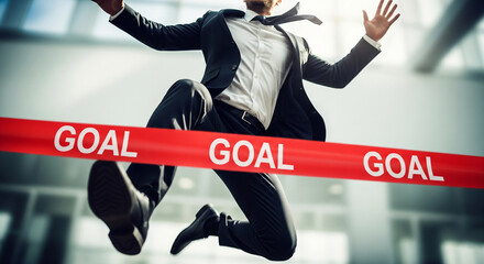 A male businessman jumping to cross the red finish line