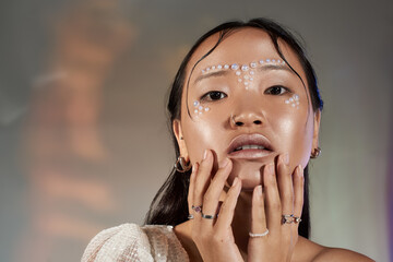 Creative beauty captured in studio with unique pearl makeup artistry on a young woman