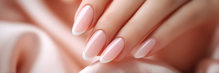Hands with a classic French manicure are gently placed on luxurious, soft fabric. The delicate pink polish contrasts beautifully with the white tips, creating an elegant look, banner