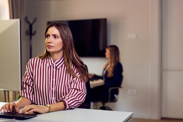 Professional Woman Working in Office with Focused Expression and Business Environment
