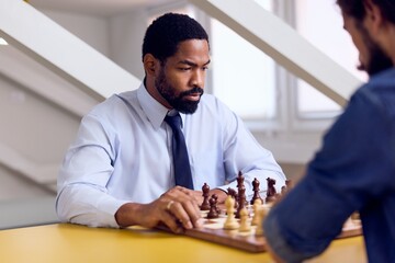 Focused African-American Male Playing Chess in a Professional Setting