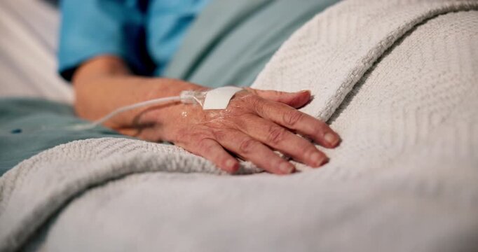 Hand, senior patient and IV drip in hospital bed for medical treatment, liquid medication or recovery. Healthcare, sick elderly person and intravenous fluid in ICU clinic for morphine and pain relief