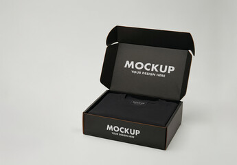 Single Folded T-Shirt Packaging Mockup in a Black Cardboard Box